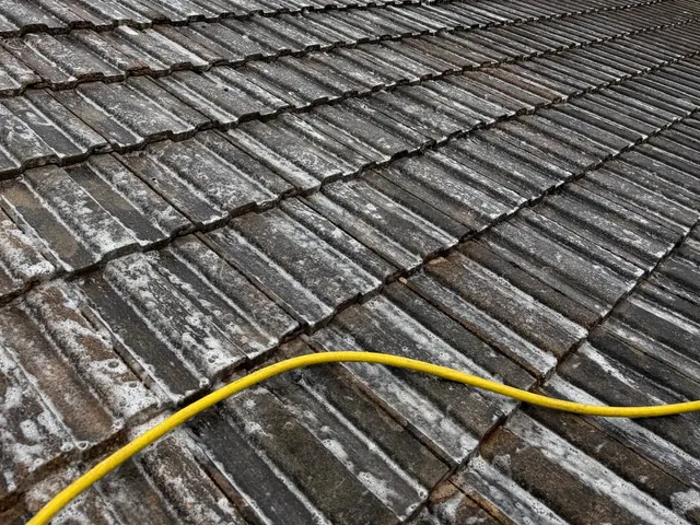 Rows of grey concrete tiles under a cloudy sky, streaked white across their faces.